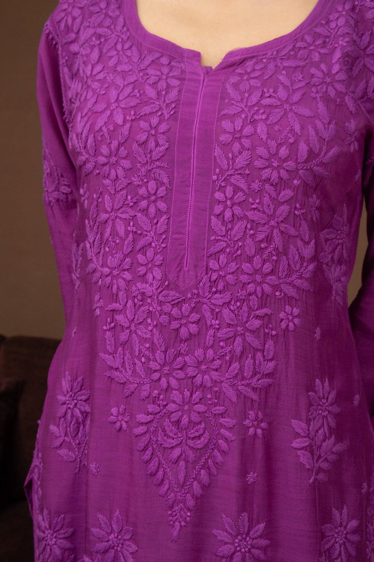 A close-up of a purple embroidered tunic or kurta with floral lace detailing and a split neckline, shown on a mannequin or model torso against an indoor background. Purple Muslin Chikankari Ghaaspatti Long Kurti with Tone-on-Tone Embroidery