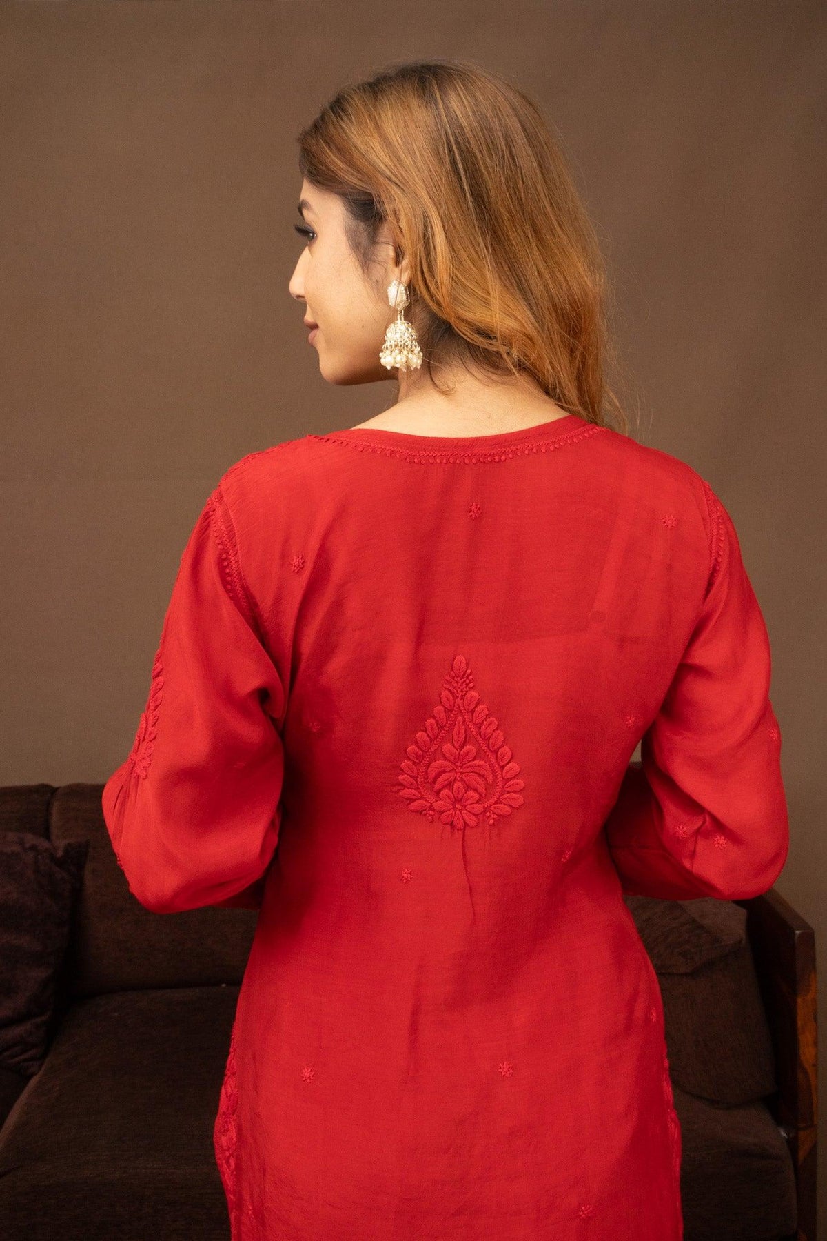 A woman shown from the back wearing a bright red long-sleeve kurta with tonal embroidery on the back, set against a warm brown background. Red Muslin Chikankari Ghaaspatti Long Kurti with Tone-on-Tone Embroidery